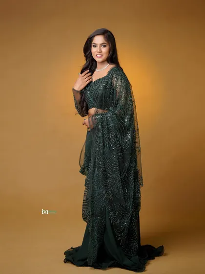 A confident and happy full-length portrait. The smile is infectious, and the pose shows off the beautiful flow of the lehenga skirt.