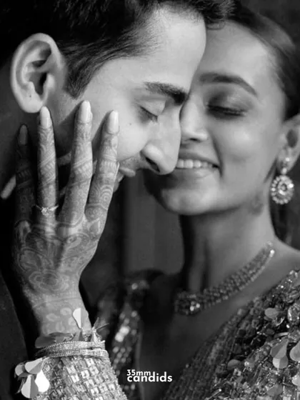 An intimate black and white close-up showing the bride's hand on her groom's cheek. This photo is all about the feeling, the gentle touch, and the quiet love that needs no words.