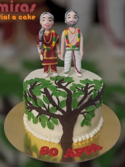 A special cake for an 80th birthday, featuring custom figurines of a couple in traditional attire standing by a tree of life. It's a beautiful tribute to a long life together.