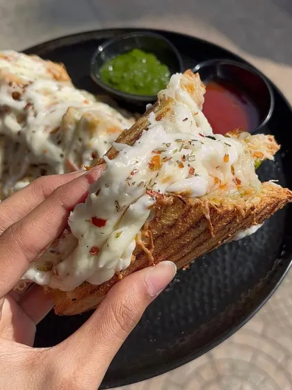 A bite of my cheesy grilled sandwich, showing the delicious filling and melted cheese.