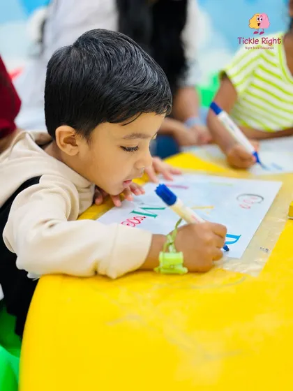 A child practices writing, his intense focus showing his dedication. Our activities help develop the fine motor skills and concentration needed for pre-writing and writing.