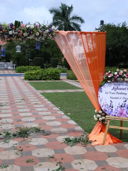 An outdoor event entrance featuring a floral arch and a matching welcome sign. This setup is ideal for garden parties or daytime functions, creating a beautiful entryway for guests.