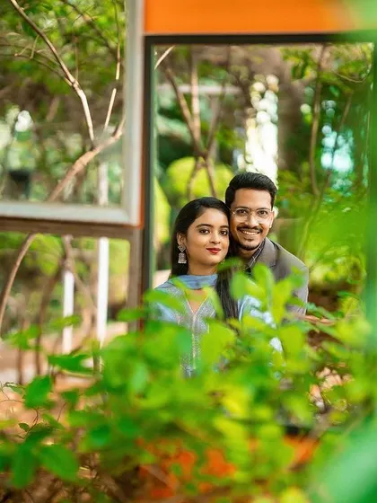A creative shot using mirrors and foliage to frame the couple in a unique way.