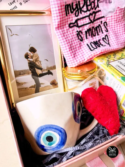A close-up of the evil eye mug and personalized photo frame from the 'Get Well Soon' hamper, designed to be full of good wishes and love.