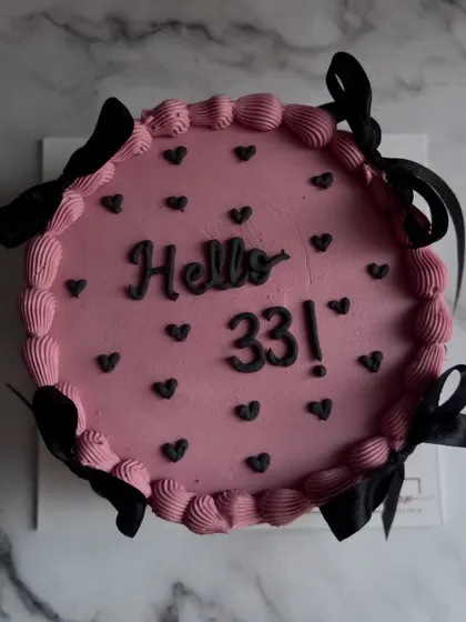 Another view of the "Hello 33" cake, showcasing the clean piping work and the playful yet sophisticated combination of pink and black.