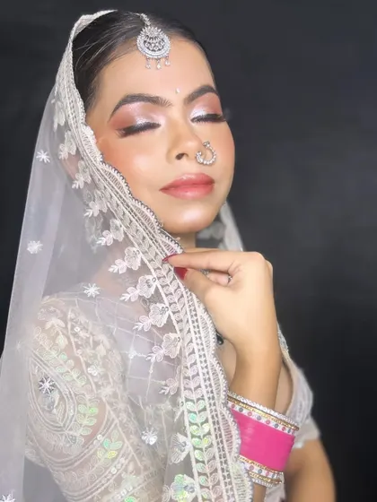 A beautiful glass makeup look on this bride. The focus is on luminous, dewy skin paired with soft, shimmering eyeshadow to create an ethereal and modern bridal style.