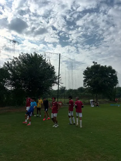 A wide view of a training session under a cloudy sky. No matter the weather, our players show up to work.