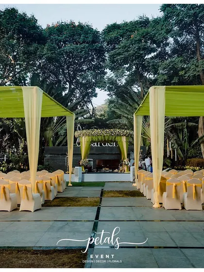 The seating arrangement for the green and yellow themed wedding. The covered chairs and open-air setting provide comfort and a beautiful view of the stunning mandap.
