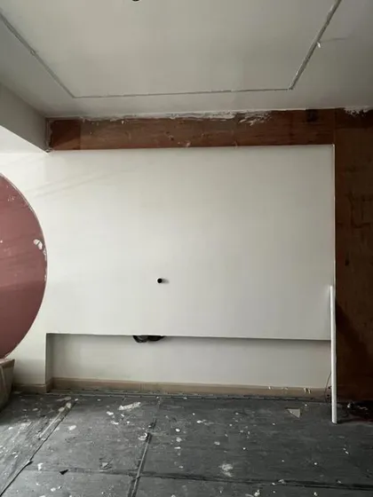 The master bedroom wall during construction, with the semi-circular cutout for the mirror being created.