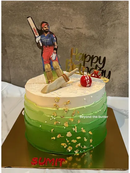 A cake for a true cricket fan. This design features an ombre green field, gold leaf details, and a topper of cricket star Virat Kohli.
