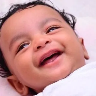 A joyful close-up capturing a baby's genuine, heartwarming smile. We focus on creating a relaxed atmosphere to capture these fleeting, precious expressions during our baby photoshoots.
