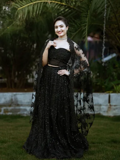 A confident pose in the black two-piece set, perfect for a red-carpet event or a glamorous reception.