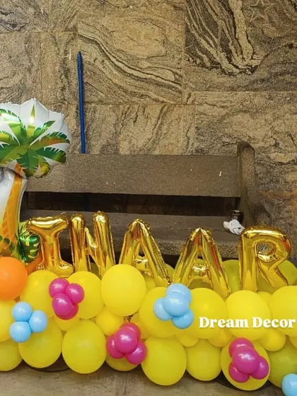 Personalized name balloons are a great addition to any theme, like in this Moana setup. The gold foil balloons add a special touch and look great in photos.