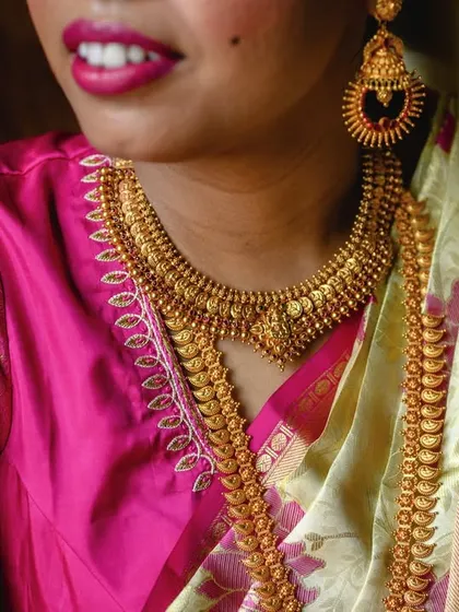 A detailed shot of the bride Amrutha's traditional South Indian gold jewelry. The craftsmanship is exquisite and an important part of her bridal attire.