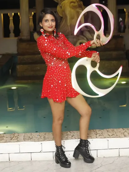 A full-length shot by the pool before a performance. This shows the complete look, from the costume and boots to the props themselves.