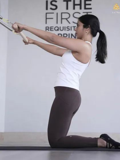 This exercise on the springboard is excellent for building arm and back strength. The focus is on maintaining a stable core and controlling the movement against the spring's resistance.