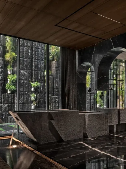For the Green Court Villa, I designed this split stone bar counter to be the heart of the entertainment space. It's not just a functional element but a sculptural masterpiece that interacts with a tranquil water body, seamlessly merging the indoors with the calming presence of nature. This is how I create immersive guest experiences.