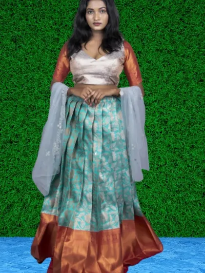 A unique fusion lehenga with a patterned light blue skirt, a contrasting border, and a simple blouse. The sheer sleeves add a delicate, modern touch.