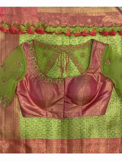 A flat lay of the green and pink saree and blouse, showing the front of the blouse.