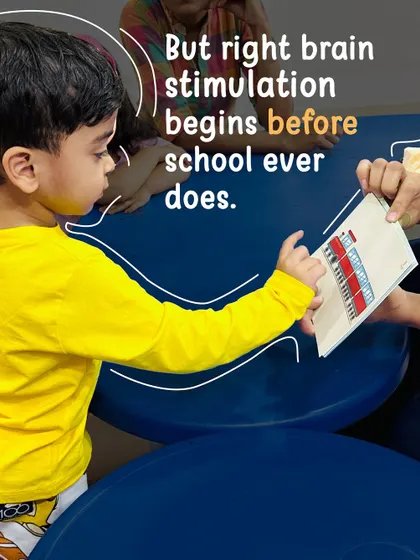 Right-brain stimulation begins long before school does. This focused interaction between a child and a trainer with a flashcard highlights how we tap into the brain's peak learning phase during the early years.