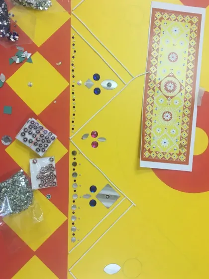 This image shows the planning stage, with a design printout and packets of mirrors ready to be applied. We carefully plan the placement of each element to match the custom design.