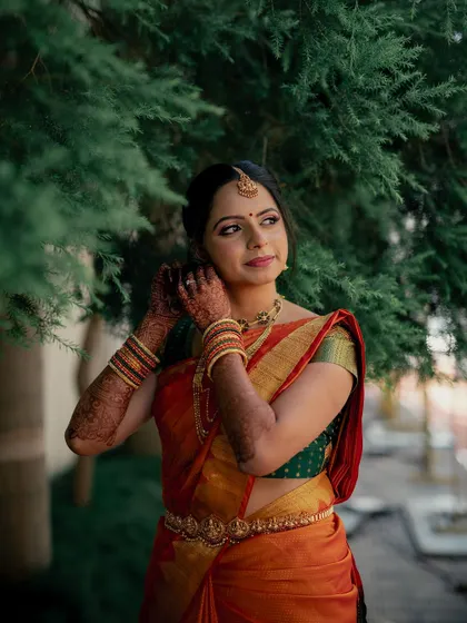 A moment of quiet elegance. The soft, traditional makeup enhances her features, allowing the beauty of her saree and antique jewellery to shine.