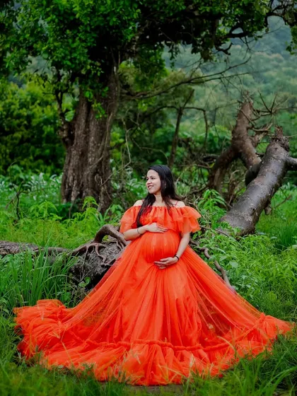 A serene moment in the forest with our orange ball gown. The vibrant color pops against the deep greens, creating a magical, fairytale-like portrait.