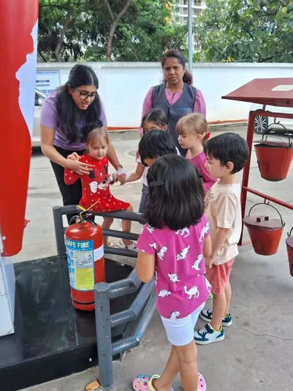 A teacher explains how a fire extinguisher works during the gas station visit, an important lesson in safety.