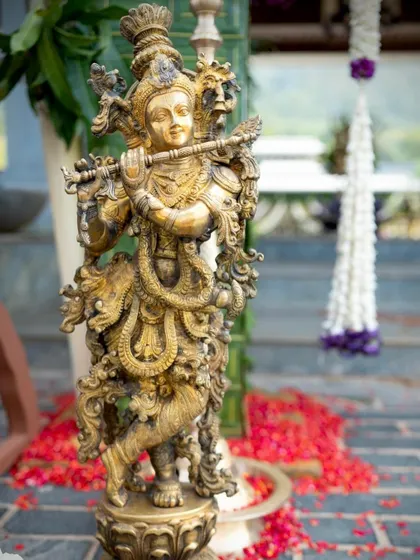 A brass statue of Lord Krishna adds a divine touch to the wedding decor.