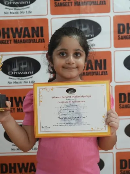 A young girl proudly presents her certificate and trophy. Our goal is to make every student feel like a star on their special day.