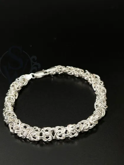 This studio shot of the King's Chain bracelet highlights the beautiful complexity of its weave. Each link is interconnected to create a fluid and powerful design.