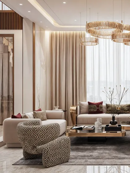 A wide shot of the living area, highlighting the multi-ring chandelier and the cohesive color palette of beige, brown, and gold.