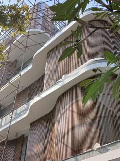 A work in progress, the Rudra Residence in Kanpur breaks from the traditional bungalow form. The sweeping curves and vertical wooden screens are part of a bold experiment in form and material.