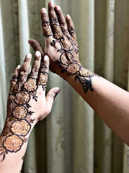 A modern and bold design featuring a trail of roses climbing up the arm. This style is great for someone who wants a contemporary tattoo-like feel with their henna.