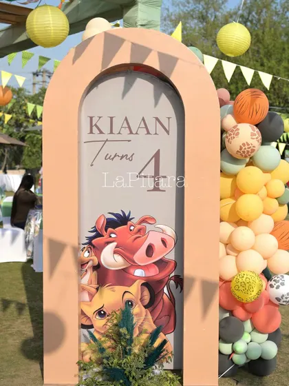 A themed archway sign for 'Kiaan Turns 4', featuring Timon and Pumbaa, adding a playful touch to the decor.