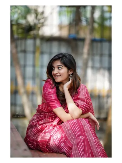 A candid and happy portrait of the same woman, capturing a moment of genuine laughter and charm.