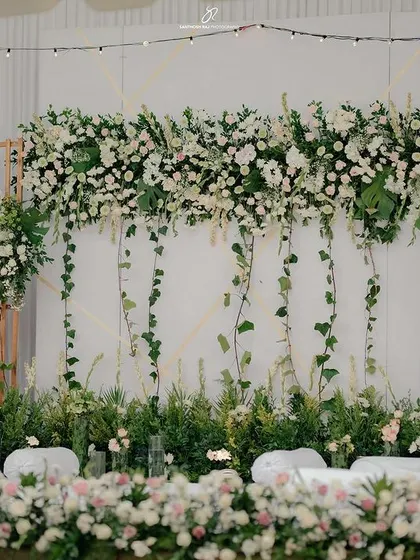 I love creating lush, modern backdrops. For this engagement, we designed a dense floral wall using a mix of premium white flowers and fresh greenery, creating a sophisticated and timeless setting for photos.