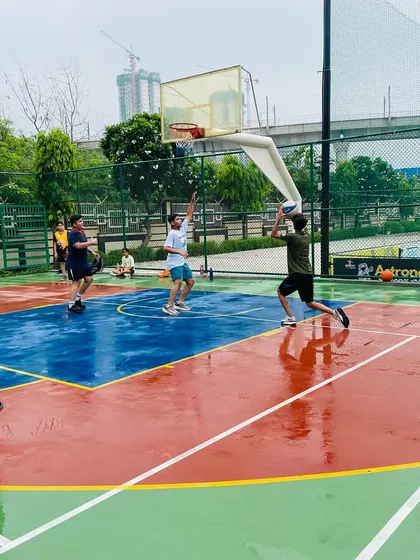 A player takes a jump shot on a wet court, showing focus and determination.