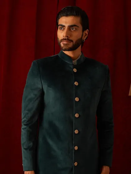 This deep green velvet bandhgala is a study in classic sophistication. The rich color and plush texture make it a luxurious choice for winter festivities and formal dinners.