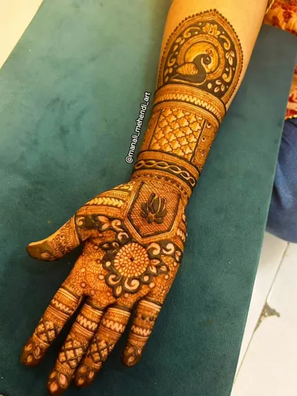 A classic design featuring a peacock motif on the arm and a lotus on the palm. This style combines popular elements of traditional Indian mehandi art.