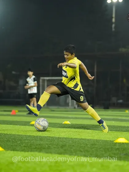 This player shows excellent technique and focus while navigating a cone drill. I teach players to keep their head up while dribbling to improve game awareness.