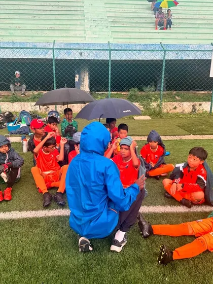 The team huddles together on the wet pitch, a testament to their dedication.