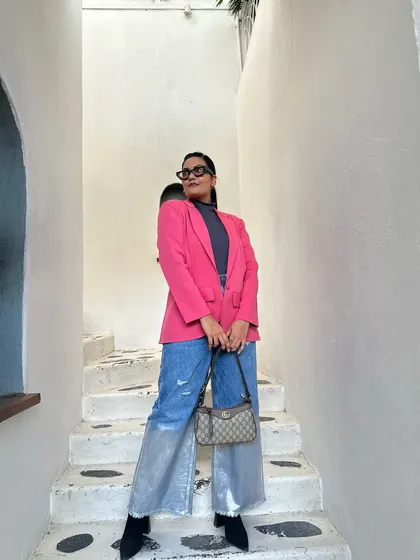 Don't be afraid of color. This look is all about making a statement with a bold pink blazer paired with wide-leg metallic jeans. It’s a powerful, confident outfit that’s perfect for making an entrance.