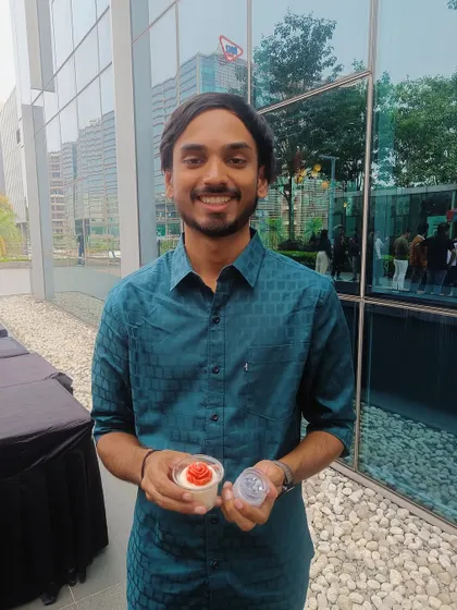 A happy guest holding the two different styles of candles he made at our interactive booth.