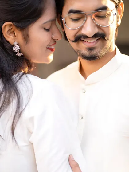 An intimate close-up that captures a quiet moment of love. The soft sunlight on their faces adds a warm, romantic glow.