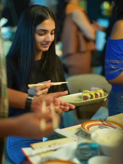 A participant gets ready to taste her handmade sushi roll. The satisfaction of eating something you've crafted yourself is what makes these experiences so special.