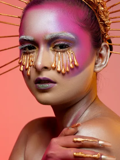 A conceptual portrait titled 'Burning Candles'. This look uses dripping gold makeup effects and creative lighting to create a surreal and artistic image, a style we love to explore in our studio.