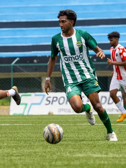 A player on the run with the ball, showcasing speed and agility as he moves past defenders in a competitive match.