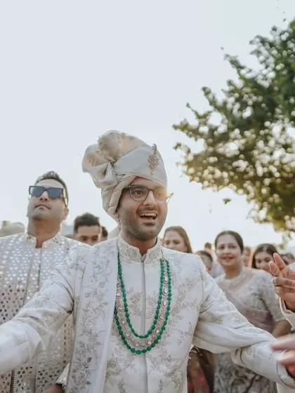 The groom's energetic dance during his Baraat, surrounded by his groomsmen and family.