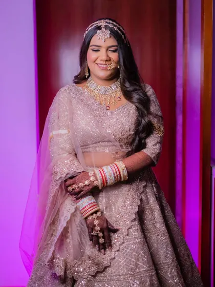 The complete bridal look, full of grace and elegance. The makeup is soft yet defined, enhancing her natural beauty and complementing her stunning attire.